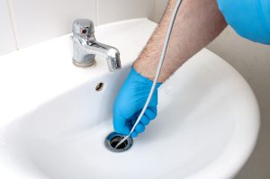 drain cleaning plumber cleaning drain with plumbers snake